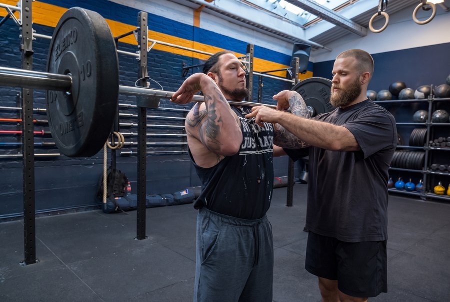 Ari Cohen coaching a client on barbell setup